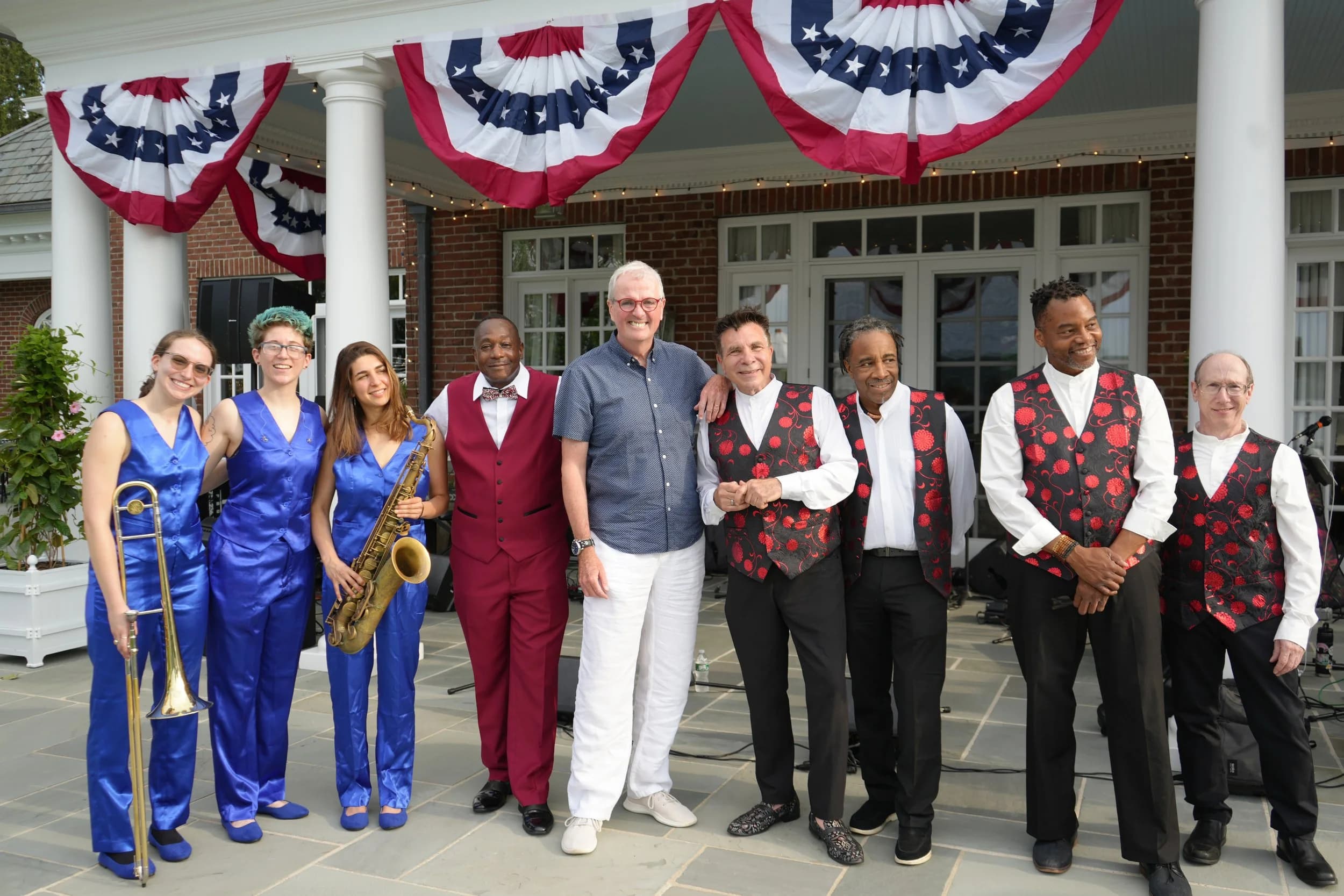 The full band together at a festive outdoor event